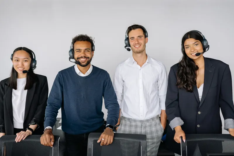 Equipe de atendimento com headsets reunida no escritório